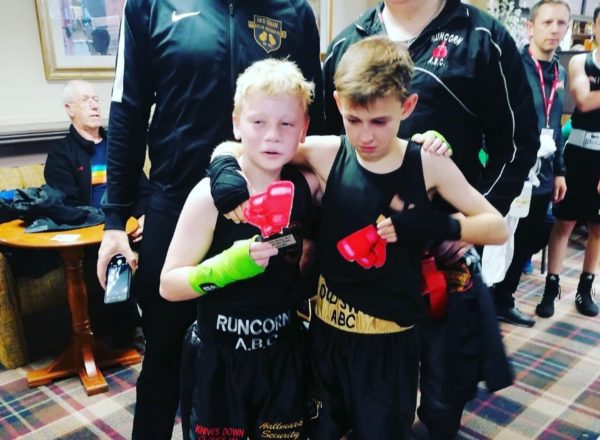 Two young boxers holding their trophies after a fight