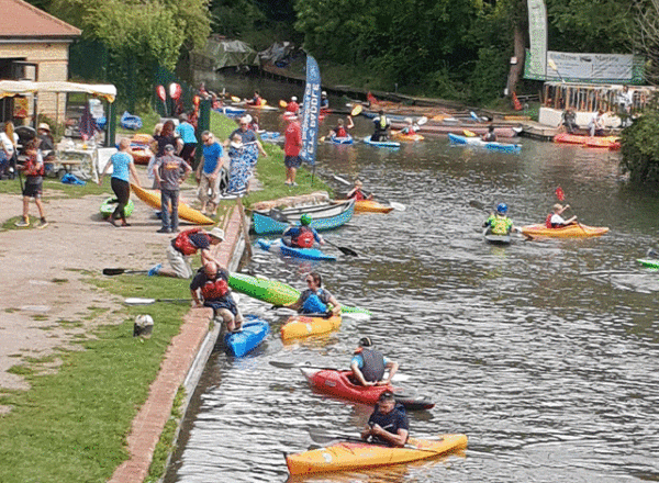 canoes and kayaks on river helping disabled young people enjoy paddlesports